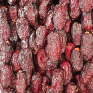 Detailed vertical shot of red dates displaying natural textures and color.