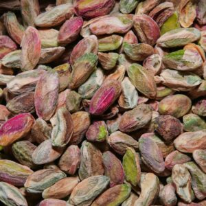 A high-resolution close-up of colorful unshelled pistachios, showcasing their natural texture and vibrant hues.