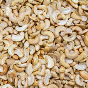 A detailed close-up of roasted cashew nuts creating a textured, appetizing backdrop.
