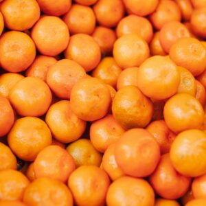 A vibrant close-up of fresh, organic oranges stacked together displaying their freshness and citrus goodness.