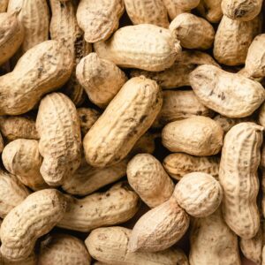A detailed close-up of raw peanuts in their shells, showcasing natural textures.